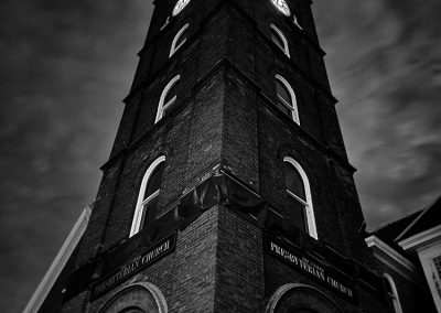Black and white photo of the United Presbyterian Church's clock tower looking tall and imposing