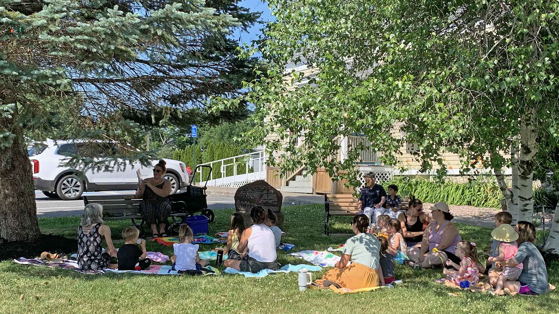 Photo of children and parents attending Story Time on the side lawn of the Visitor Center in 2023