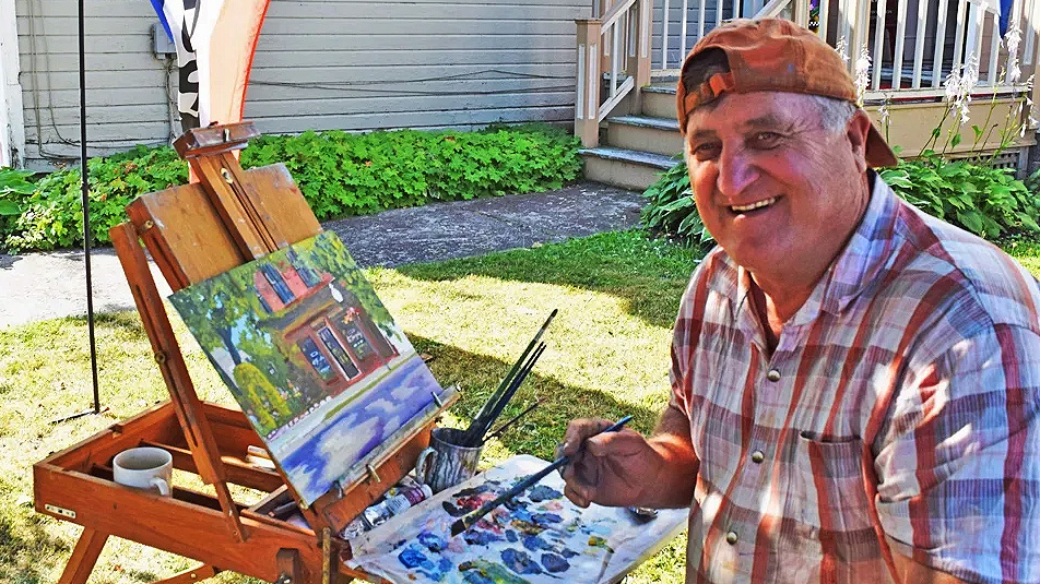 Photo of an artist painting outside the Sackets Harbor Arts Center at the 2022 Plein Air Art Festival