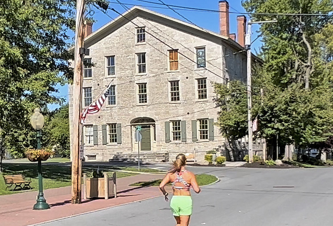 Photo of runner passing by the Union Hotel in Sackets Harbor