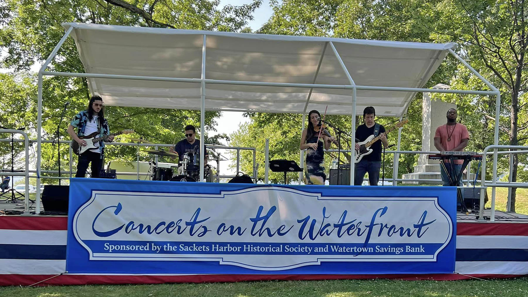 Photo from one of the 2023 Concerts on the Waterfront with the band on stage at the Sackets Harbor Battlefield