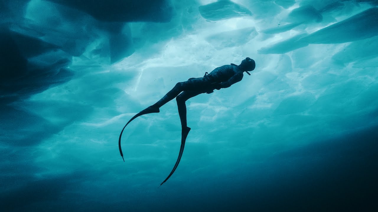Still image of a diver swimming beneath ice from the "Great Lakes Untamed" documentary series