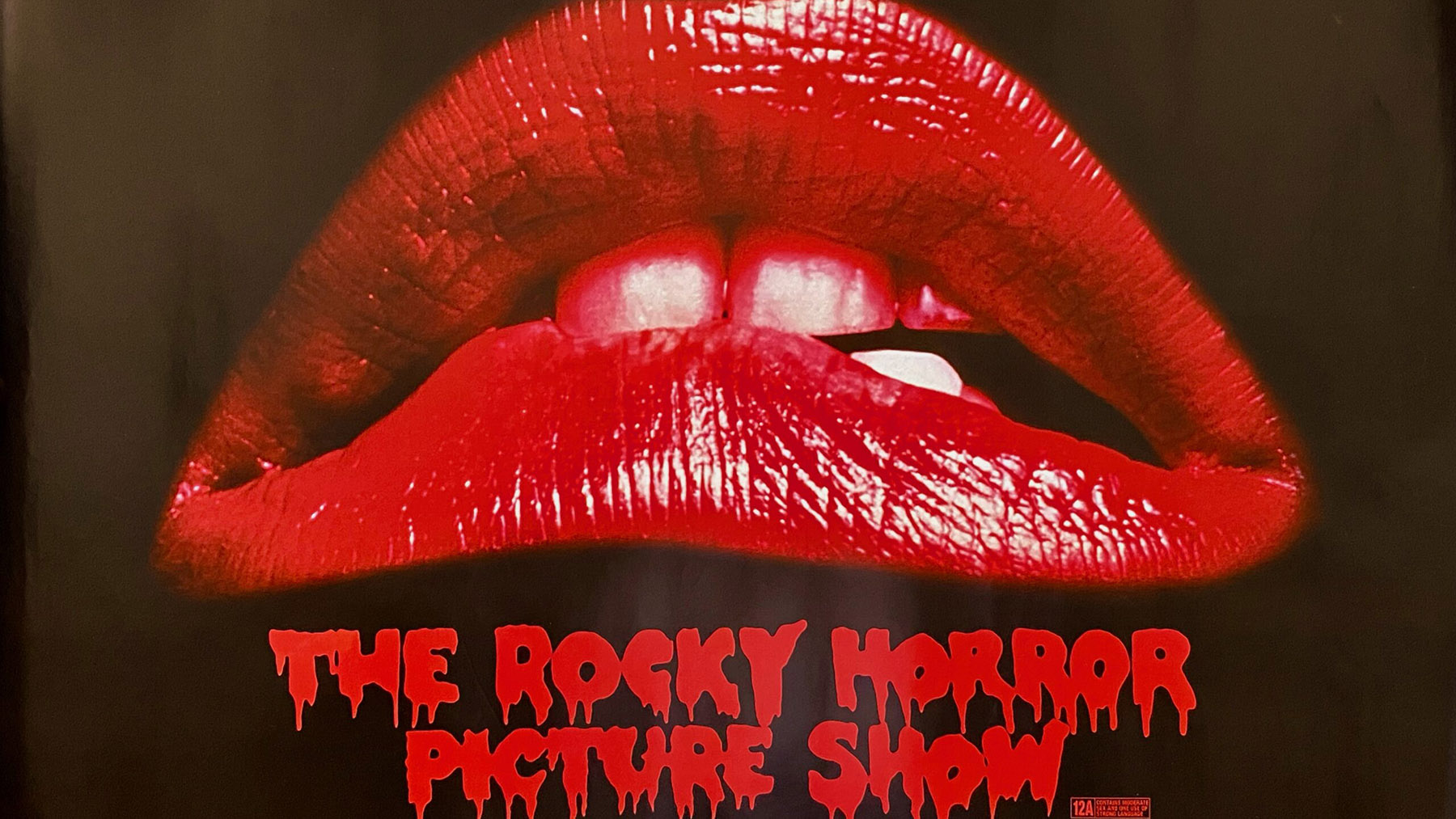 A cropped portion of a promotional poster for The Rocky Horror Picture Show